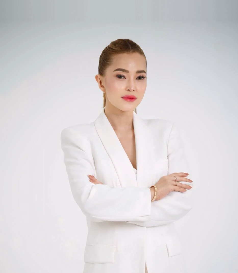 Nicole in a white suit with her arms crossed